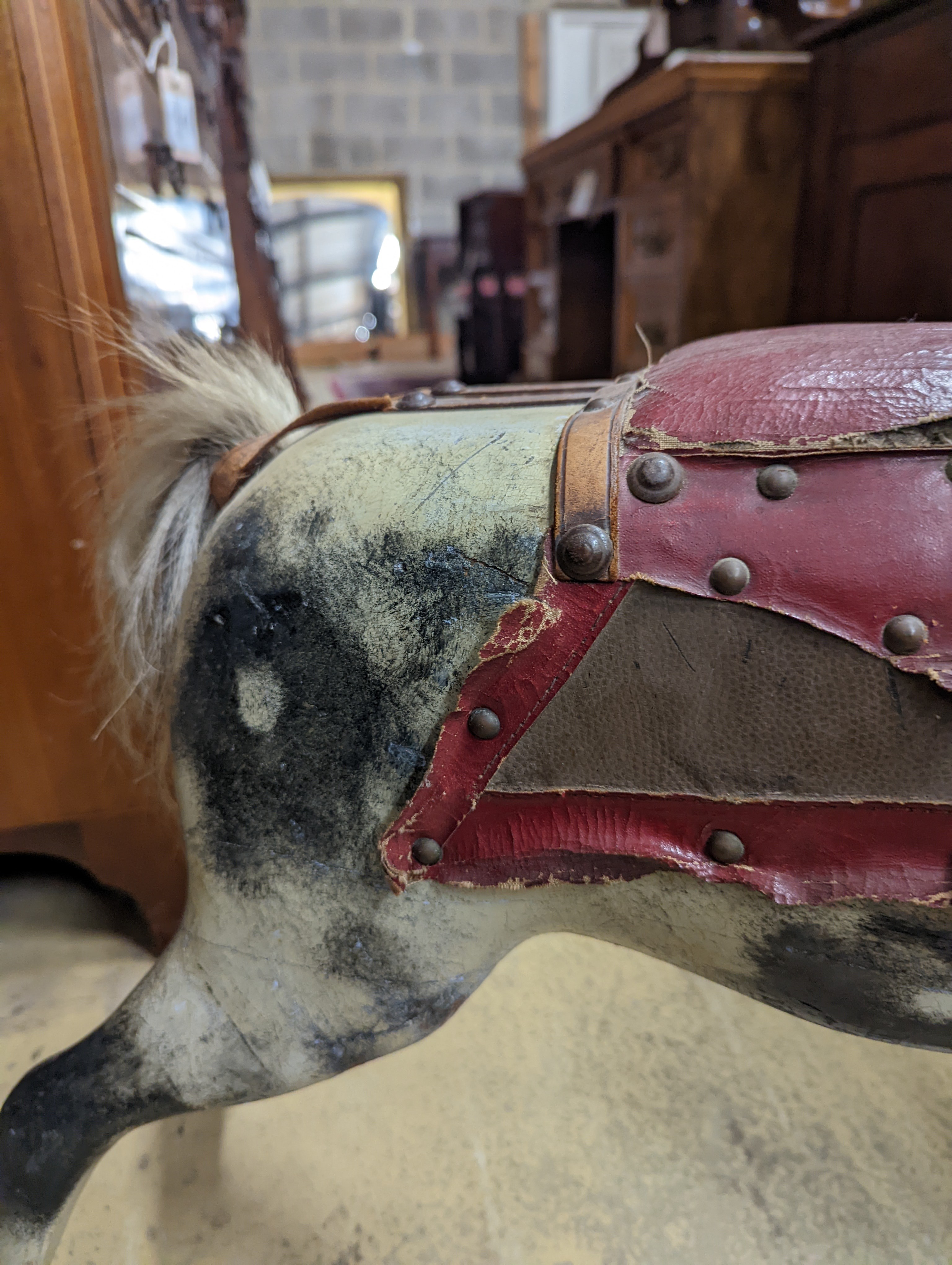 A Victorian carved and painted wood rocking horse, lacking underframe, length 77cm and two painted wood hobby horses, 58cm and 38cm